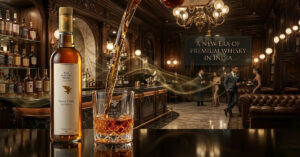 The Nation Pride Indian Whisky bottle with rich amber liquid in a glass on wooden table