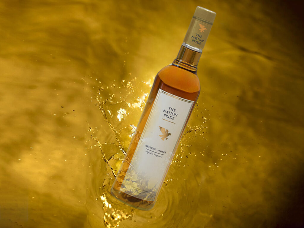 TheNationPrideWhisky displayed on a wooden table with elegant lighting